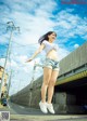 A young woman jumping in the air on a street.