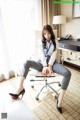 A woman sitting on a chair in a hotel room.