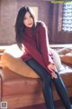 A woman sitting on top of a brown couch.