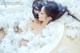 A woman laying in a bathtub covered in fluffy white cotton.