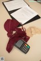 A calculator sitting on top of a table next to a bra.