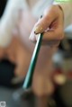 A woman's hand holding a green pen. 