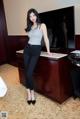 A woman standing in front of a desk in a hotel room.