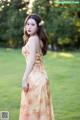 A woman in a long dress standing in a field.