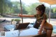 A woman in a bikini pointing at something on a table.