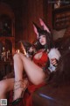 A woman in a bunny costume sitting on a couch.