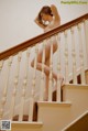 A naked woman is standing on the stairs. 