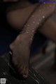 A close up of a woman's legs in fishnet stockings.