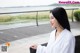 A woman in a white robe sitting on a bench.