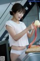 A woman cutting up a piece of fruit on a cutting board.